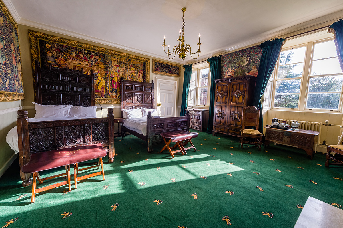 Decorative wall coverings and antique twin beds in the Tufton bedroom at Appleby Castle