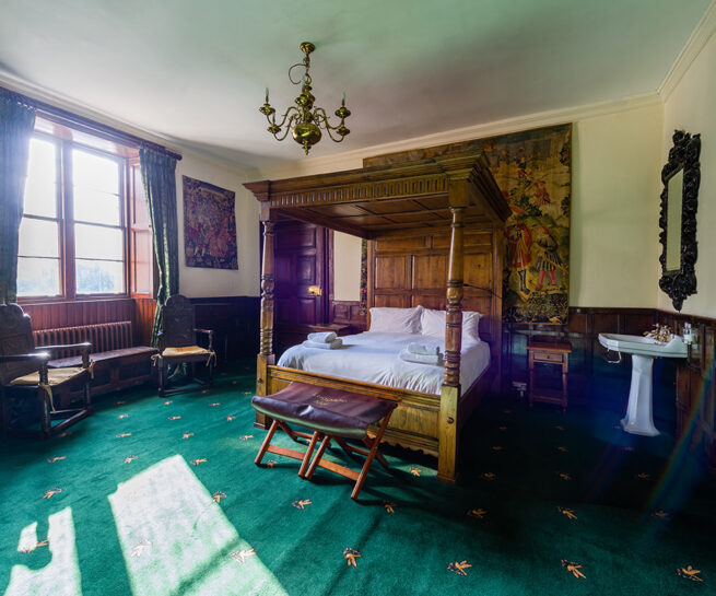 Four poster antique bed and antique wall coverings in the Vipont bedroom at Appleby Castle
