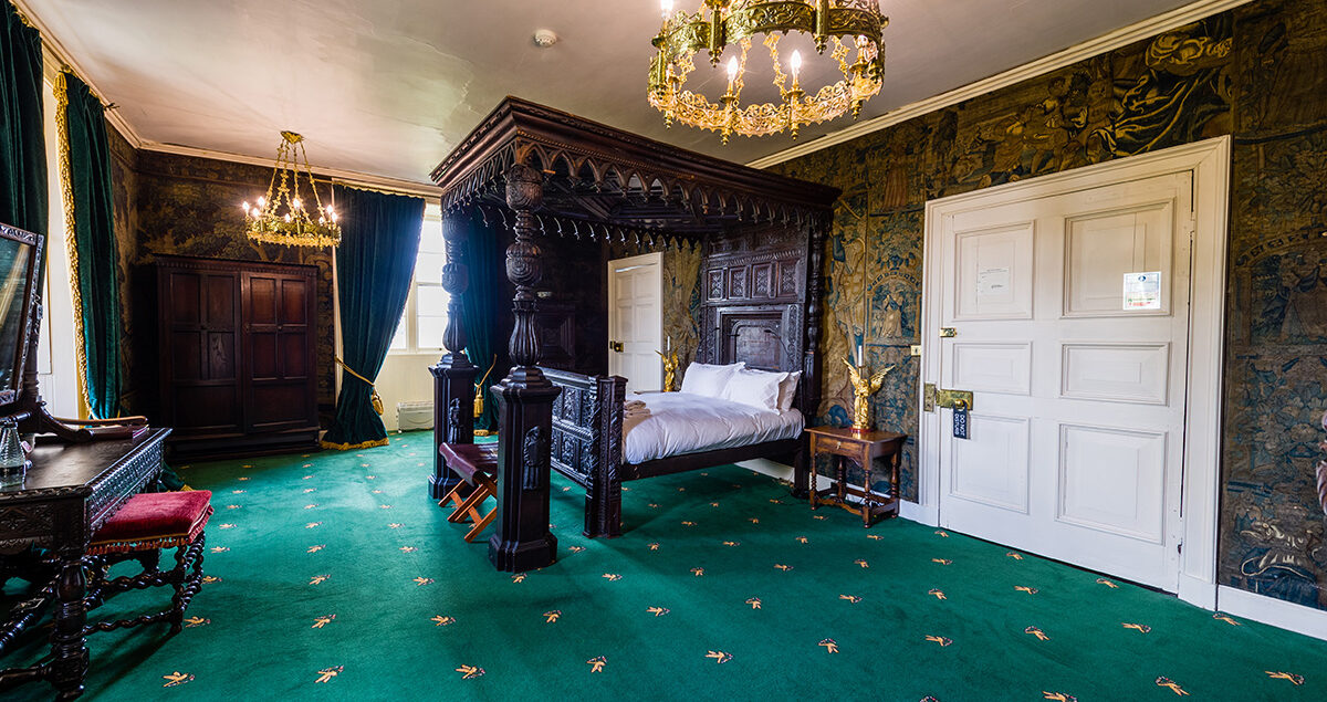 Large four poster bed and antique wall coverings in the State bedroom at Appleby Castle