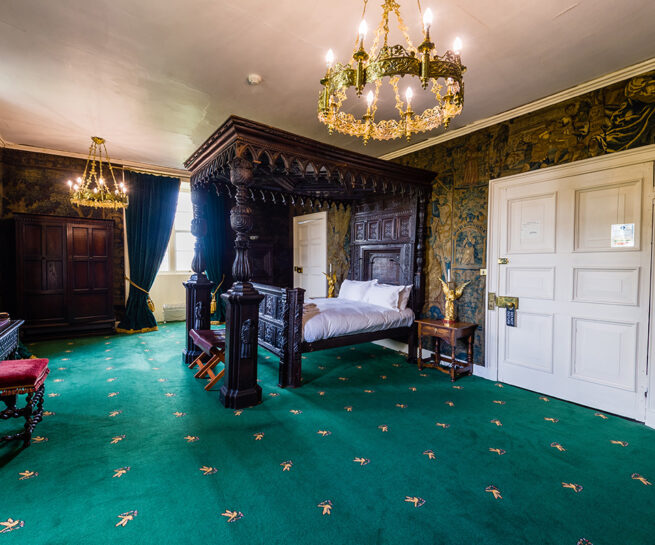 Large four poster bed and antique wall coverings in the State bedroom at Appleby Castle