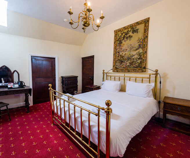 Brass bed and decorative antiques in the Atkinson bedroom at Appleby Castle
