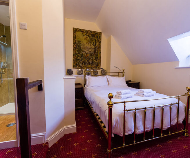 Brass bed and decorative wall covering in the Sackville bedroom at Appleby Castle