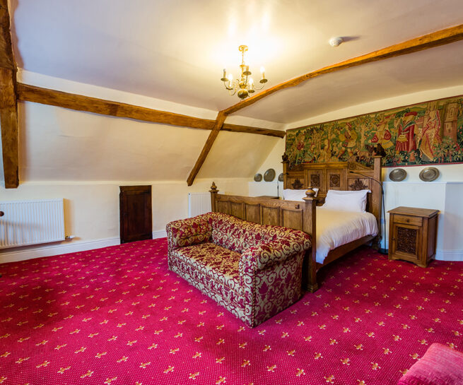 Large bed and sofa in the Russel Suite bedroom at Appleby Castle