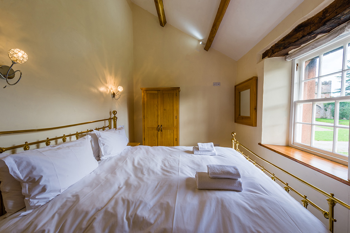 Large brass bed in the self-contained holiday cottage at Appleby Castle in Cumbria